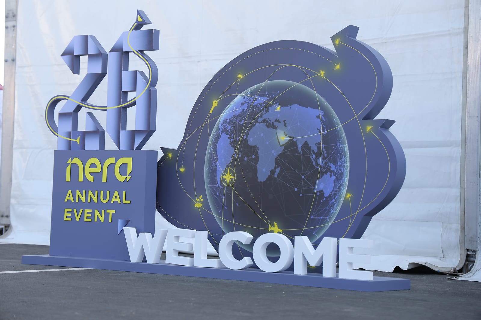 A large sculpted welcome sign with a globe and the number 26 at the entrance of the SANS annual event.
